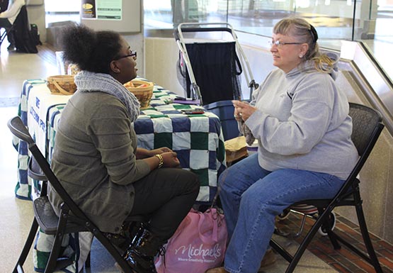 Linda Harie-Mould, right, speaks with student Kristian Tull during her hours captaining The Listening Post, a twice-weekly space for people to speak about whatever is on their minds. 