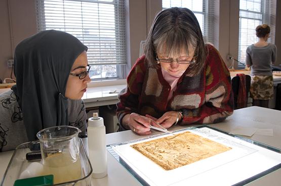 Professor Judith Walsh works with a student in the art conservation paper lab.