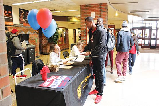 Sarah Velez (director of the union) assisting Criminal Justice major Brandon Brown, senior, register to vote for next year’s USG candidates.