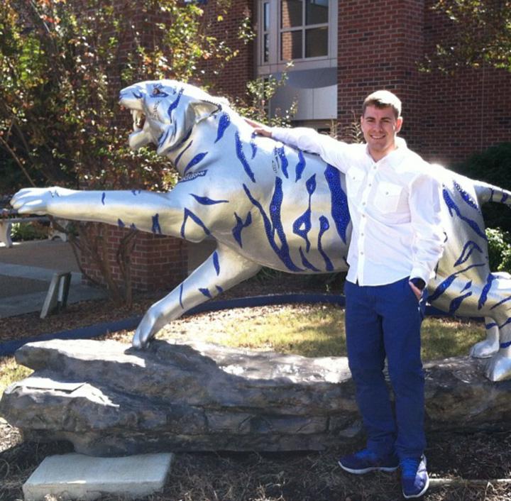 Montana is pictured with a Tiger statue in the University of Memphis campus.