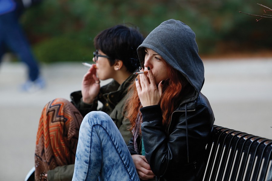Two Buffalo State students smoke near the Campbell Student Union Quad. While there is a tobacco-free policy on campus, Buffalo State is not responsible for enforcing the policy.