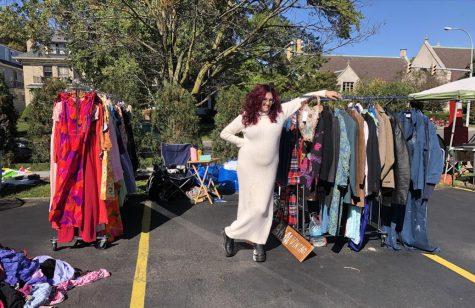 Woman standing in parking lot with racks of vintage clothing