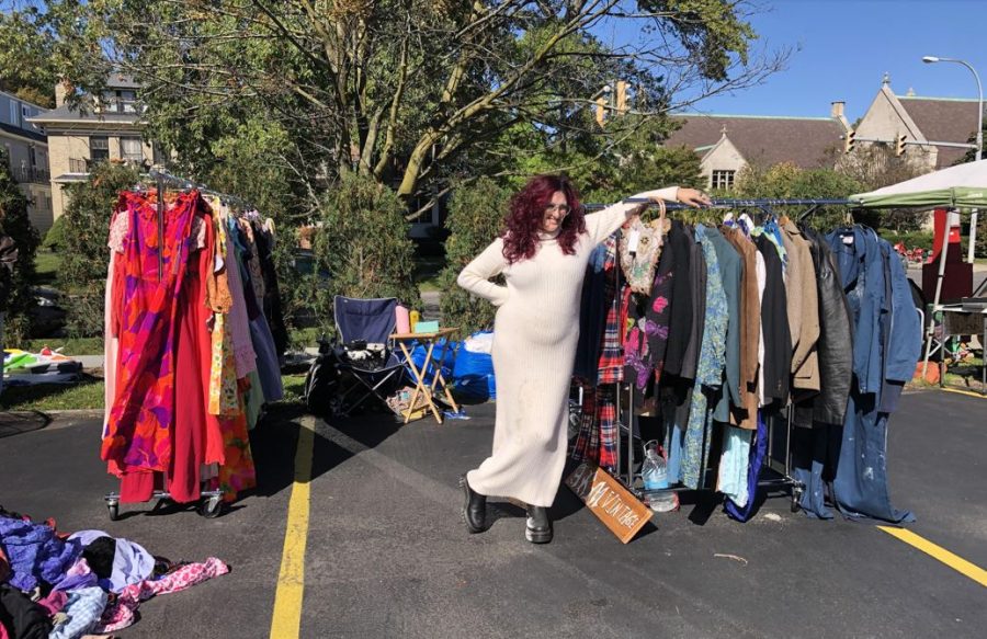 Woman+standing+in+parking+lot+with+racks+of+vintage+clothing