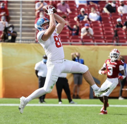 Casey Kelly catching a pass on a football field.