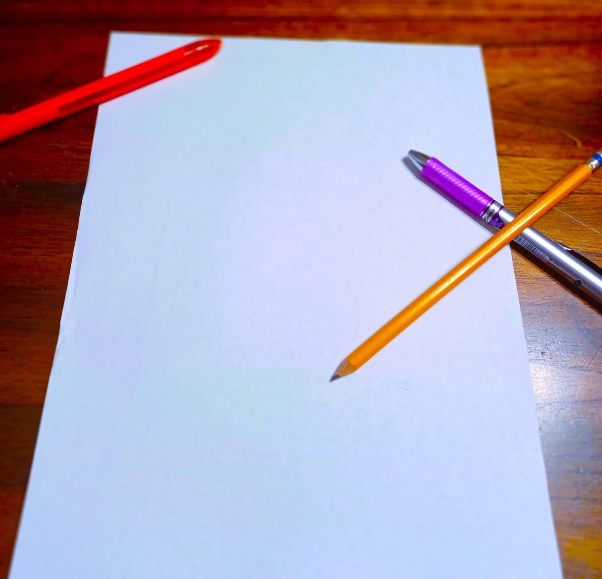 A photo of a piece of paper with writing utensils.