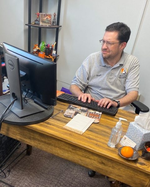 Professor O'Donnell sitting behind his desk typing.