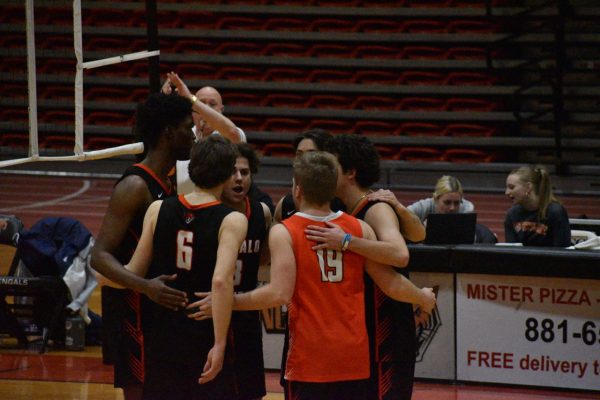 The team huddles between serves. 