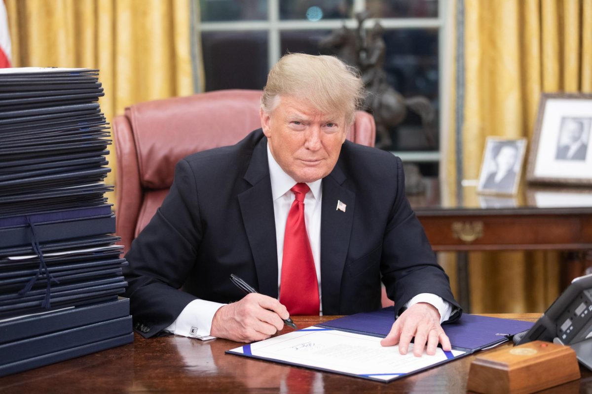 Donald Trump signing documents in the Oval Office
