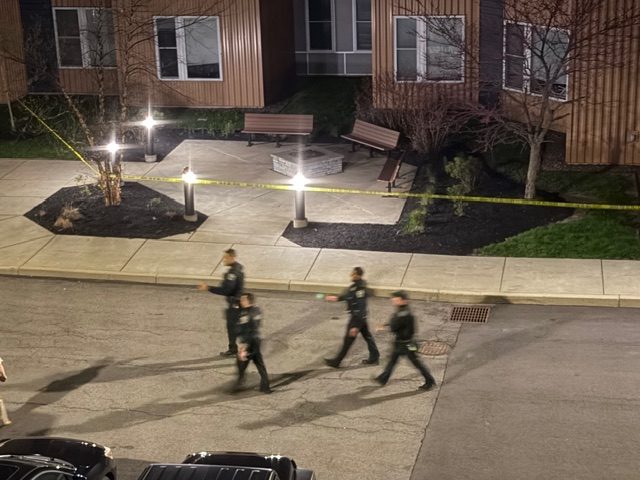 Multiple Buffalo Police officers outside of Campus Walk examining the scene